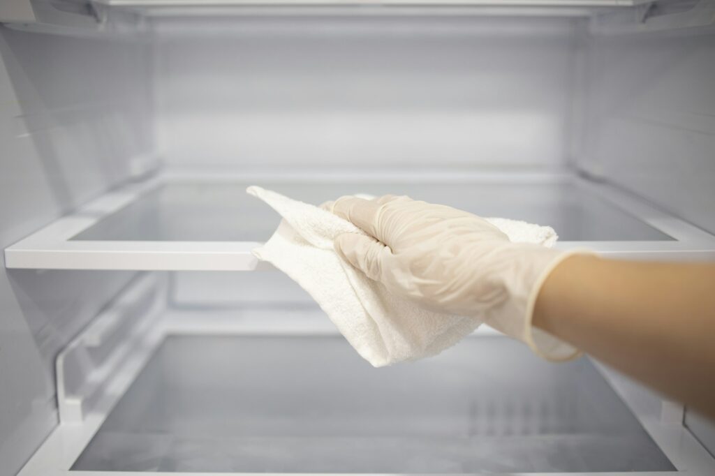 Housewife or cleaning service clean up empty fridge with napkin